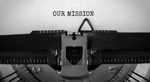 A typewriter and paper with a focus on the company mission